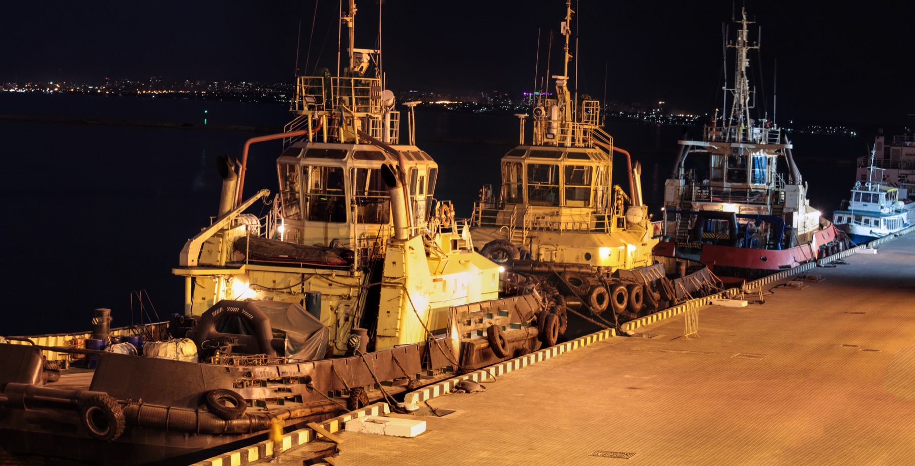Commercial vessels operating in port at night